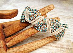 a pair of wooden sticks with beaded bracelets on top of each other, sitting on a table