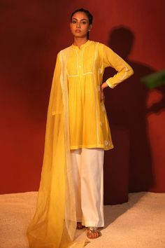 Yellow gathered kurta with thread, sequin embroidery on yoke. Paired with wide legged pant and dupatta.
Components: 3
Pattern: Embroidery
Type Of Work: Thread, sequin
Neckline: Mandarin collar
Sleeve Type: Long sleeves
Fabric: Mul Chanderi, Lining: Mulmul
Color: Yellow
Other Details: 
Front and back gathered
Lace border embroidered sheer dupatta
Front button detailing
Weight: Approx 1 kg
Model height: 5 ft 6 inches, wearing size M
Occasion: Sangeet - Aza Fashions Haldi Dresses, Yoke Embroidery, Plain Suits, Sheer Dupatta, Haldi Dress, New Embroidery Designs, Satin Fashion, Short Kurta, Kurta Set For Women