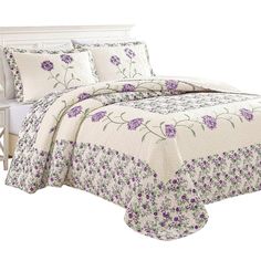 a white bed with purple flowers on it