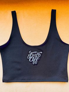 This cutesy crop tank packs a punch with its bold, "F Off" patch in classic black. It's the perfect blend of risk-taking attitude and fun. Patch: "F*ck Off" Made of 4 way stretch Dritex fabric. Sugarpuss Size Chart + Care Instructions Shipping Info Black Cotton Sports Bra For Summer, Black Cropped High Stretch Tank Top, Black High Stretch Cropped Tank Top, Black High Stretch Crop Top Sports Bra, Black Sporty Tank Crop Top, Sporty Black Tank Crop Top, Sleeveless Sports Crop Top With Letter Print, Sleeveless Letter Print Crop Top For Sports, Black Tank Crop Top For Sports