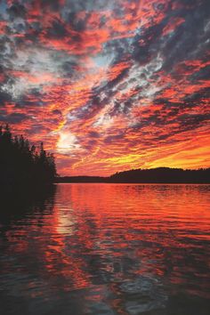 the sky is reflected in the water at sunset