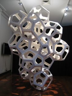 a sculpture made out of white paper on top of a hard wood floor