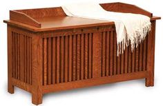 a wooden bed with white sheets on top of it and a blanket hanging from the headboard