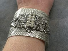 This cocktail bracelet for women is a bangle cuff with rhinestones and is beautiful Art Deco Jewelry. It is adorned with a silver plated brass stamping, a sparkly rhinestone bar. The cuff bracelet is heavy and etched with basket weave designs. The pieces are bolted together securely, and the rhinestone bar is affixed securely with wire in between so it has a 3 dimensional aspect to it. This will adjust to many wrist sizes, although best suited for a medium sized wrist. It is 2 inches wide, and m Glamorous Rhinestone Cuff Bangle Bracelet, Silver Bling Cuff Bracelet For Evening, Adjustable Jeweled Silver Cuff Bracelet, Silver Bling Cuff Bangle Bracelet, Silver Adjustable Cuff Bracelet With Rhinestones, Adjustable Silver Cuff Bracelet With Rhinestones, Adjustable Silver Cuff Bracelet With Diamond Accents, Glamorous Silver Cuff Bracelet With Rhinestones, Silver Cuff Bracelet With Diamond Accents As Gift