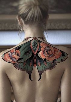 the back of a woman's body with flowers on it and a butterfly tattoo