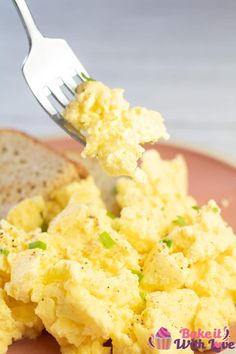 a fork with scrambled eggs and bread on it