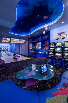 a brightly lit bowling alley with arcade machines in the background and blue lighting on the ceiling