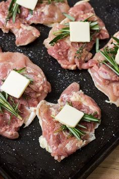 raw meat with herbs and cheese on a black plate