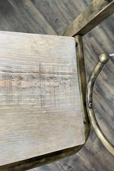 a wooden table with metal legs and a handle on the top that has been scratched off