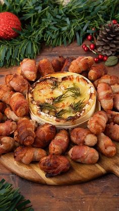 a platter filled with food on top of a wooden table next to christmas greenery