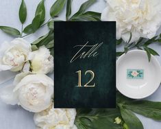 a table number with white flowers and greenery