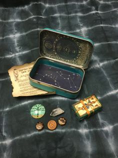 an open tin box with buttons and other items