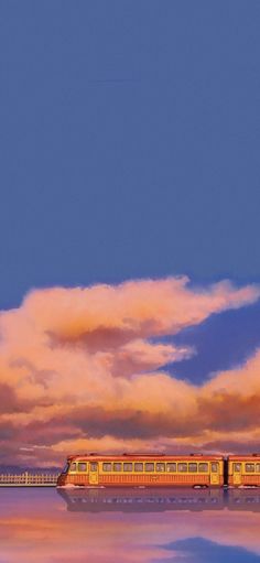 a train traveling across a large body of water under a cloudy blue sky with pink clouds