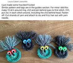 three crocheted eyes are sitting on top of a wooden table next to each other