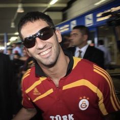 a man wearing sunglasses is smiling at the camera while standing in front of other people