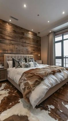 a large bed sitting next to a window in a room with wood paneled walls