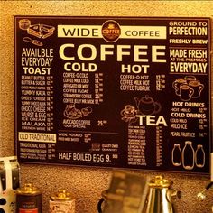 a coffee shop menu on the wall next to some cups and kettles in front of it