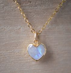 Handcrafted in 14k Gold Filled this Rainbow Moonstone pendant is sure to make your heart skip a beat! Rainbow moonstone is a clear to white gemstone that flashes shades of blue or rainbow colors. It is believed to enhance feminine energies, psychic abilities, and encourage hope. It's also said to bring abundance to one's life, and is one of the birthstones for June.Each pendant is faceted and contains a mix of blue or rainbow flash. They are edged in 24k gold electroplate and set onto a 14k gold Minimalist White Heart-cut Jewelry, Minimalist White Heart Cut Jewelry, White 14k Gold Heart-shaped Jewelry, Heart-shaped 14k White Gold Jewelry, Dainty White Moonstone Jewelry, White Heart-shaped Moonstone Jewelry, Elegant Heart-shaped Moon Charm Jewelry, Elegant Heart-shaped Jewelry With Moon Charm, Dainty Heart-shaped Gemstone Jewelry