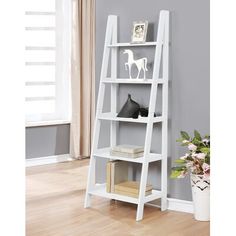 a white bookcase with three shelves and two vases on the floor next to it