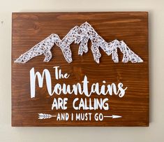 a wooden sign that says the mountains are calling and i must go with some crochet on it