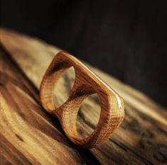 a wooden ring sitting on top of a piece of wood