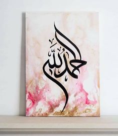 an arabic calligraphy is displayed on a shelf in a room with pink and gold paint