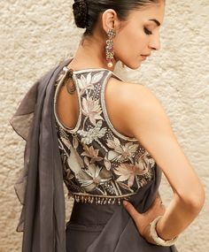 Elevate your style with our alluring grey draped sari where playful ruffles steal the spotlight. Crafted on a luxe organza base, this ensemble exudes elegance. The halter-neck blouse is a true investment piece, featuring exceptional resham threadwork adorned with pearls, sequins, and beads, all meticulously hand-done by expert craftsmen. Halter Neck Blouse, Blouse Necklines, Halter Neck Blouses, Grey Drapes, Draped Saree, Ruffle Saree, Drape Saree, Hem Blouse, Beaded Neckline