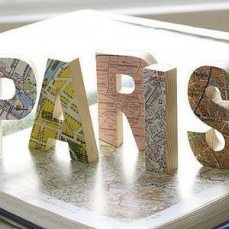 the word paris spelled with wooden letters on top of a map book cover that says paris