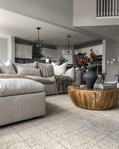 a living room filled with furniture and a large wooden table in the middle of it