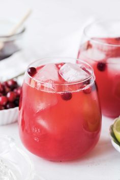 two glasses filled with cranberry punch and garnished with cherries