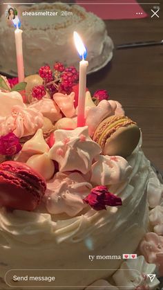 a birthday cake with two candles on top and flowers around the edges, sitting on a table