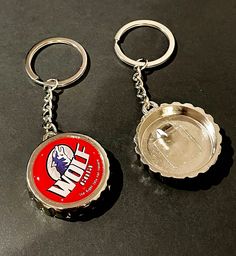 two beer bottle caps sitting next to each other on top of a black countertop