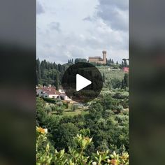 a video screen with trees and buildings in the distance, on a hill top overlooking a town