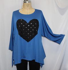 Limited edition, angled Traveler knit tops, appliquéd with a  Shiny Dot fabric Black Heart, One Size fits 1X,2X,3X Bust, Side seam to side seam: 59" total Length at Center Back: 28" Sleeve length from center back: 20 1/2" Done in a  polyester spandex, Traveler knit, trimmed with Shiny Dot fabric Black Heart, shown with the Black slim leg pant, sold in a separate listing in my shop . The top has a scoop neck, with drop shoulder long sleeves, front and back center  seaming, and winded angled sides Slim Leg Pants, Plus Size Top, Dotted Fabric, Black Heart, Slim Legs, Knit Top, Womens Clothing Tops, Spandex, Tunic Tops