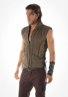 With its distinctive Viking flavor the Odin vest is durable and hard wearing. Made from 100% cotton this double lined vest will keep you warm even on the longest winters night. The inner lining is a soft cotton, the outside is hard wearing canvas weave. It has a zip up front with leather detail panels, brass studs, lace up sides, and an array of open and zipper pockets in the front with an extra breast pocket in the lining, It also boasts an elegant leather hand braiding embellishment down the s Sleeveless Denim Vest For Festivals, Sleeveless Winter Vest For Festivals, Alternative Sleeveless Vest For Alternative Fashion, Steampunk Black Sleeveless Vest, Steampunk Style Sleeveless Black Vest, Black Steampunk Sleeveless Vest, Black Sleeveless Steampunk Vest, Winter Punk Sleeveless Vest, Winter Sleeveless Punk Vest