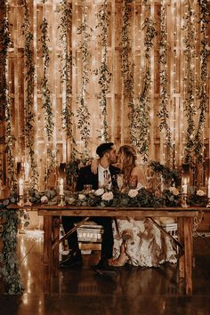 a man and woman sitting at a table kissing