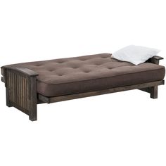 a brown futon bed sitting on top of a wooden floor next to a white pillow