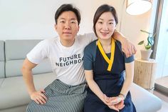 two people sitting on a couch posing for the camera