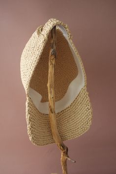 a straw hat is hanging on a stick