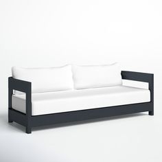 a black and white couch sitting on top of a white floor next to a wall