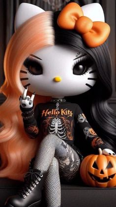 a hello kitty doll sitting next to a pumpkin