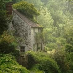 an old stone house surrounded by trees and bushes