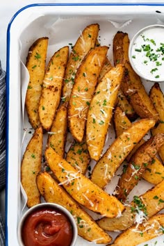 french fries with ketchup and parmesan cheese in a white tray on a table