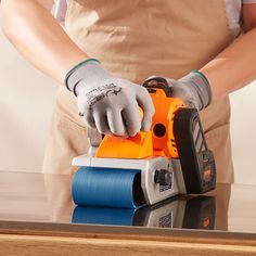 a person using a sander on top of a table