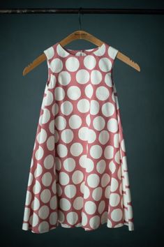 a red and white dress hanging on a hanger