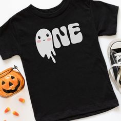 a black t - shirt that says one on it with a ghost and pumpkins next to it