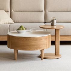 a coffee table with two cups on it in front of a couch