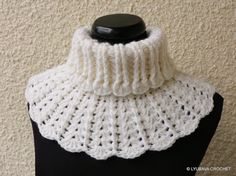 a white crocheted cowl on top of a black mannequin