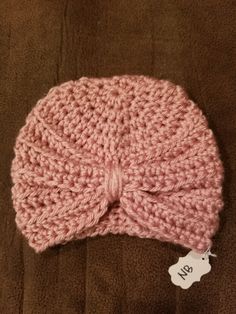 a pink knitted hat with a tag on it