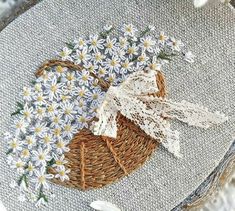 a basket filled with daisies on top of a table next to a white cloth